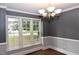 Elegant dining room with wainscoting detail, hardwood floors, and a decorative light fixture at 3209 Leebrook Rd, Raleigh, NC 27616