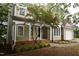 Inviting home entrance with covered porch, lush landscaping, and a well-manicured lawn at 3209 Leebrook Rd, Raleigh, NC 27616