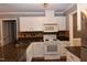 Eat-in kitchen features a stainless steel refrigerator, white appliances, tile backsplash, and granite countertops at 3209 Leebrook Rd, Raleigh, NC 27616