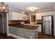 Updated kitchen features white cabinets, stainless steel appliances, granite countertops, and tile backsplash at 3209 Leebrook Rd, Raleigh, NC 27616