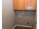 Laundry room features oak upper cabinets and wood look flooring at 3209 Leebrook Rd, Raleigh, NC 27616