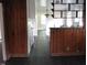 View of hallway with wood panelling, hardwood floors, and pass through to kitchen at 3514 S Alston Ave, Durham, NC 27713