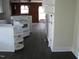 Kitchen with a white stove, white cabinets, shelving, and dark vinyl plank flooring at 3514 S Alston Ave, Durham, NC 27713
