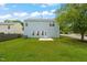 Grassy backyard featuring a light-blue two-story home with a concrete patio at 518 Clearfield Dr, Durham, NC 27703