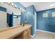 Well-lit bathroom with a single sink, vanity, and a large mirror with an adjacent commode and tiled shower/tub at 518 Clearfield Dr, Durham, NC 27703