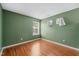 View of an empty bedroom with hardwood floors and two windows with neutral paint at 518 Clearfield Dr, Durham, NC 27703