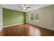 Spacious bedroom with hardwood floors, a ceiling fan, and a large window overlooking the outdoors at 518 Clearfield Dr, Durham, NC 27703