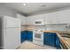 Efficient kitchen with white appliances, subway tile backsplash, and butcher block countertops at 518 Clearfield Dr, Durham, NC 27703
