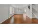 Open-concept living area with hardwood floors, large windows, and a staircase leading to the upper level at 518 Clearfield Dr, Durham, NC 27703