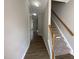 Hallway with wood floors leading to carpeted stairs and rooms with neutral paint at 545 Writers Way, Morrisville, NC 27560
