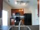 Kitchen featuring dark appliances, brown cabinets, and a gray backsplash at 545 Writers Way, Morrisville, NC 27560