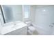 Bright bathroom features a white vanity, toilet, and tub-shower combination at 5916 Longeria Ct, Raleigh, NC 27612