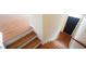Entryway featuring hardwood steps with white trim, leading to a black front door at 5916 Longeria Ct, Raleigh, NC 27612