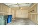 Unfinished garage interior with painted drywall, showing access to house and trash cans at 5916 Longeria Ct, Raleigh, NC 27612