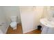 Cozy half bath featuring a pedestal sink, toilet and modern finishes at 5916 Longeria Ct, Raleigh, NC 27612