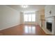 Bright living room with a fireplace, large windows and gleaming hardwood floors at 5916 Longeria Ct, Raleigh, NC 27612