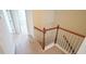 Carpeted staircase featuring wooden handrail and white balusters at 5916 Longeria Ct, Raleigh, NC 27612
