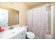 A functional bathroom with a sink, toilet, and shower featuring a patterned curtain at 612 Agin Court Pl, Clayton, NC 27520