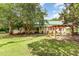 Well-manicured lawn with a pergola situated near the house surrounded by mature trees at 6200 Us-401 S, Bunnlevel, NC 28323