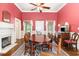 Inviting dining room features a fireplace, ceiling fan, wood floors, large windows, and a traditional oval table at 6200 Us-401 S, Bunnlevel, NC 28323