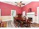 Inviting dining room features a fireplace, ceiling fan, wood floors, and a traditional oval table at 6200 Us-401 S, Bunnlevel, NC 28323