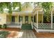 Charming home showcasing a light yellow exterior, green metal roof, and inviting entrance with a covered porch at 6200 Us-401 S, Bunnlevel, NC 28323