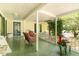 Covered porch featuring green painted floor, wicker chairs, traditional white railings, and serene outdoor views at 6200 Us-401 S, Bunnlevel, NC 28323