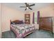Comfortable bedroom with ceiling fan, window and purple patterned quilt and dark wood furniture at 6408 Glen Brack Ct, Raleigh, NC 27603