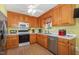 Functional kitchen with stainless steel appliances, white countertops, and wood cabinetry at 6408 Glen Brack Ct, Raleigh, NC 27603
