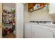 Functional laundry room with washer, dryer, and shelving for storage at 6408 Glen Brack Ct, Raleigh, NC 27603