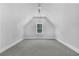 Finished attic with neutral carpet, white walls and trim, with a large window at 6900 Staghorn Ln, Raleigh, NC 27615