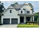 Attractive two-story home with white siding, gray trim, large windows, and two-car garage at 6900 Staghorn Ln, Raleigh, NC 27615