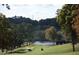 Picturesque golf course with rolling hills, trees, and a serene lake adding to the scenery at 6900 Staghorn Ln, Raleigh, NC 27615