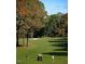 Scenic golf course view with lush green fairways, mature trees, and golfers on the course at 6900 Staghorn Ln, Raleigh, NC 27615