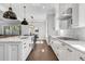 Gourmet kitchen boasts stainless appliances, custom cabinets, quartz countertops, and hardwood flooring at 6900 Staghorn Ln, Raleigh, NC 27615