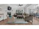 Spacious living room with fireplace, modern ceiling fan, and an open view to the dining area at 6900 Staghorn Ln, Raleigh, NC 27615