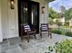 Inviting front porch with bluestone pavers and seating area with stylish chairs and pillows at 6900 Staghorn Ln, Raleigh, NC 27615