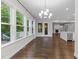 Inviting dining area with chandelier and multiple windows providing backyard access and ample natural light at 7502 Latteri Ct, Raleigh, NC 27613