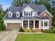 Charming two-story home featuring a blend of brick and white siding, a well-manicured lawn, and an attached two-car garage at 7502 Latteri Ct, Raleigh, NC 27613