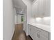 Bright hallway featuring white cabinetry with countertop, hardwood floors, and recessed lighting at 7502 Latteri Ct, Raleigh, NC 27613