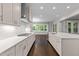 Modern kitchen with white marble countertops, a herringbone tile backsplash, and stainless steel appliances at 7502 Latteri Ct, Raleigh, NC 27613