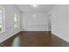 Elegant living room with decorative wall trim, gleaming hardwood floors, and abundant natural light from the large window at 7502 Latteri Ct, Raleigh, NC 27613
