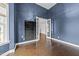 Sophisticated office with blue walls, hardwood floors, natural light, and glass French doors at 7502 Latteri Ct, Raleigh, NC 27613