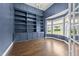 Stylish office with built-in bookshelves, hardwood floors, a bay window, and elegant blue walls at 7502 Latteri Ct, Raleigh, NC 27613