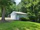 Two car garage with white doors and light gray siding surrounded by a green lawn and lush trees at 78 Phil Johnson Rd, Sanford, NC 27330