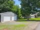 View of the two-car garage next to a house surrounded by beautiful green trees and landscaping at 78 Phil Johnson Rd, Sanford, NC 27330