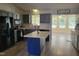 Bright kitchen with gray cabinets, center island with white countertop, and stainless steel appliances at 78 Phil Johnson Rd, Sanford, NC 27330