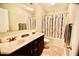 Bathroom features a double sink vanity, tile flooring, and a shower-tub combo with patterned curtain at 83 Mariners Point Way, Garner, NC 27529