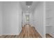 Hallway featuring wood-look floors, bright lighting, white walls, and convenient access to other rooms at 834-836 Day Ave, Burlington, NC 27217