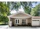 A covered back porch area with an outdoor seating area, white posts, double doors and a grill at 835 Pearleman Teague Rd, Siler City, NC 27344
